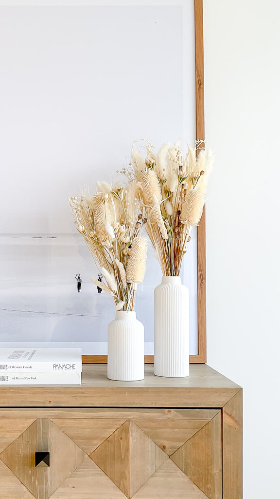 tall and short ceramic vases with dried flower bouquets